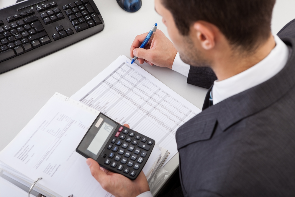 male accountant working with calculator