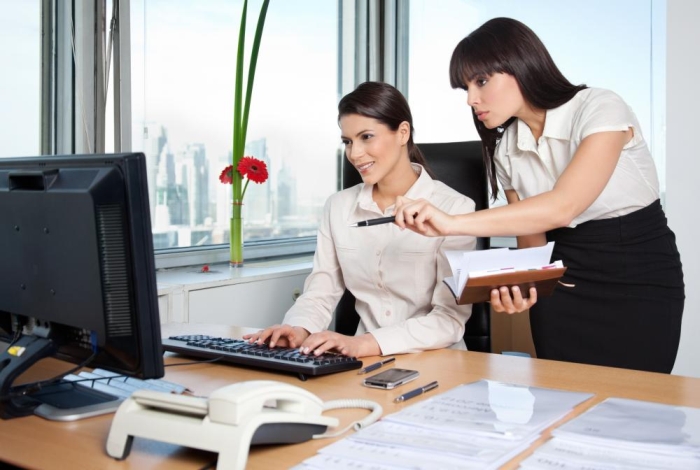 woman showing colleague something on the computer